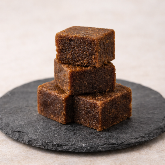Stack of brownies on a dark slate surface with a neutral background