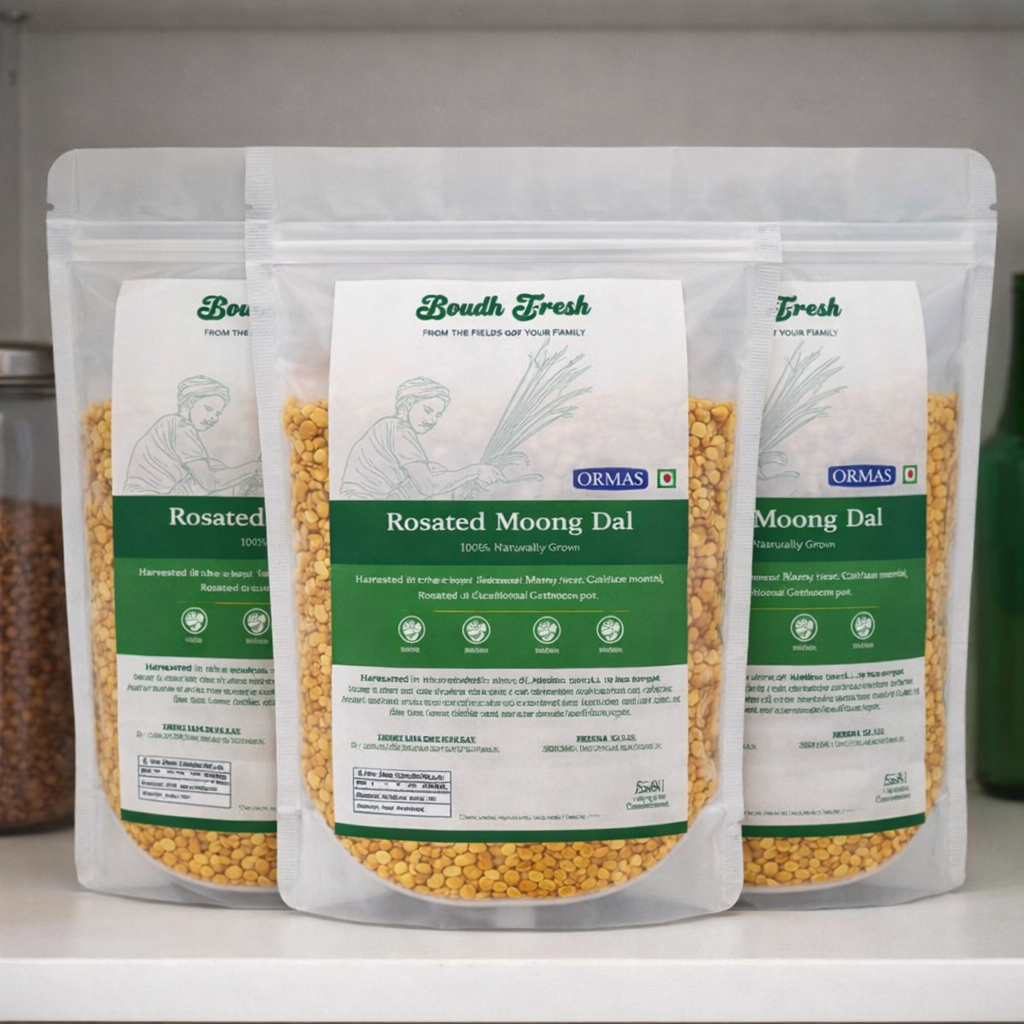 Three packages of Ormas Rosated Moong Dal on a white surface with a blurred background.