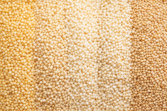 Close-up of uncooked quinoa grains in three different shades.