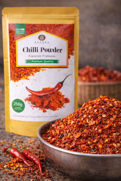 Chili powder package with a bowl of chili powder on a dark surface