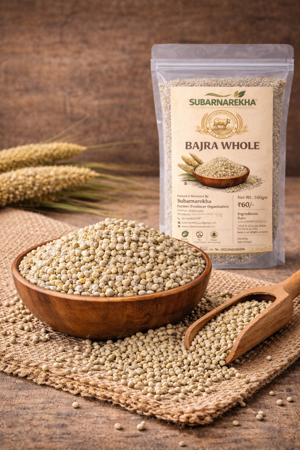 Bajra whole grains in a wooden bowl with a Subarnarekha packaging in the background.