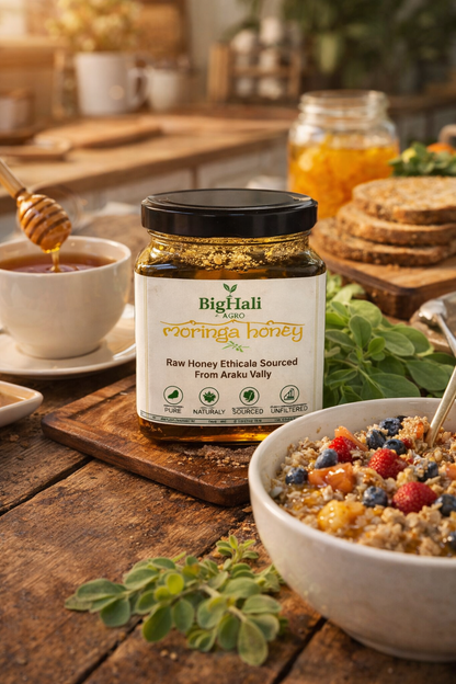 Jar of Big Flaki's Ecorica honey on a wooden table with a bowl of cereal and honey dipper.