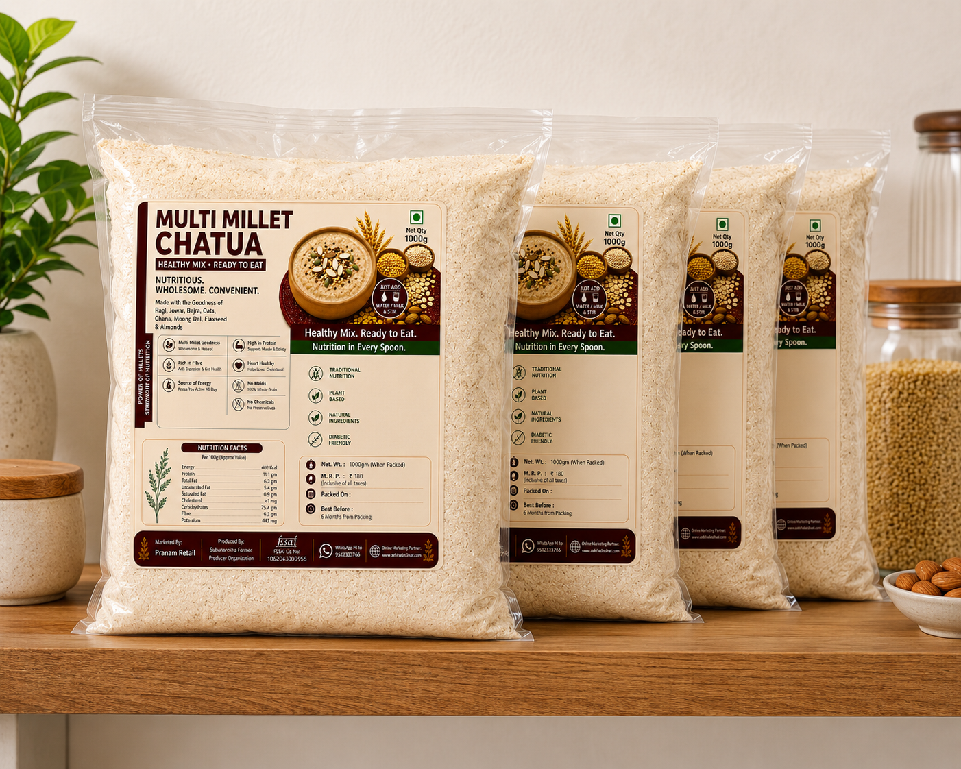 Three packages of Multi Millet Chatura on a wooden shelf with a plant and jars in the background.