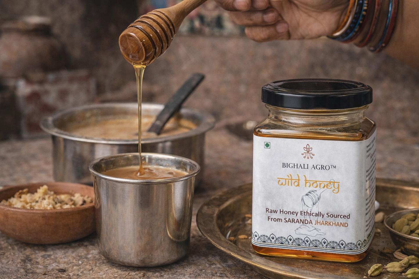 Honey being drizzled into a pot with a jar of Bighali Agro wild honey in the foreground.