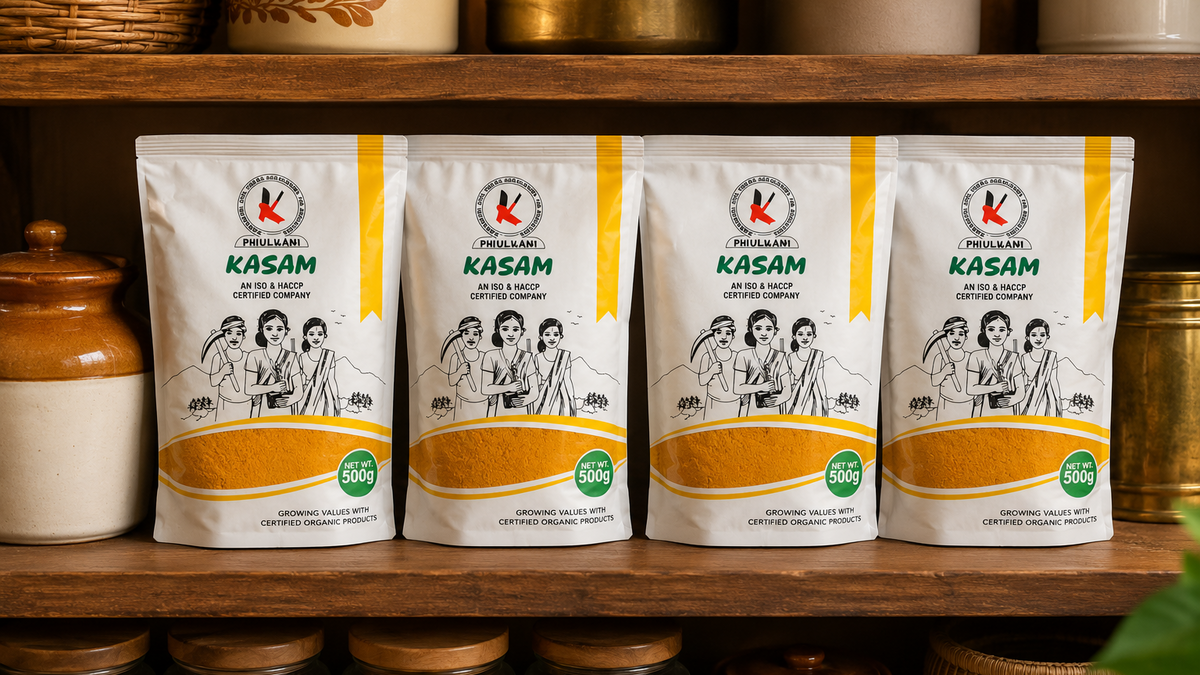 Four 'Kasam' branded packages on a wooden shelf with jars and containers in the background.