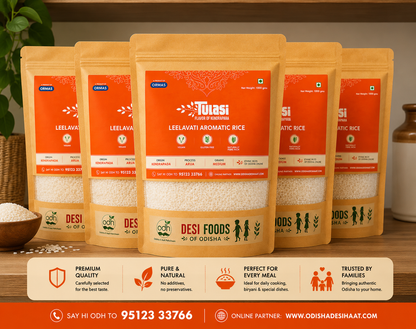 Five packages of Tulasi Desi Foods rice on a wooden surface with a plant and container in the background.