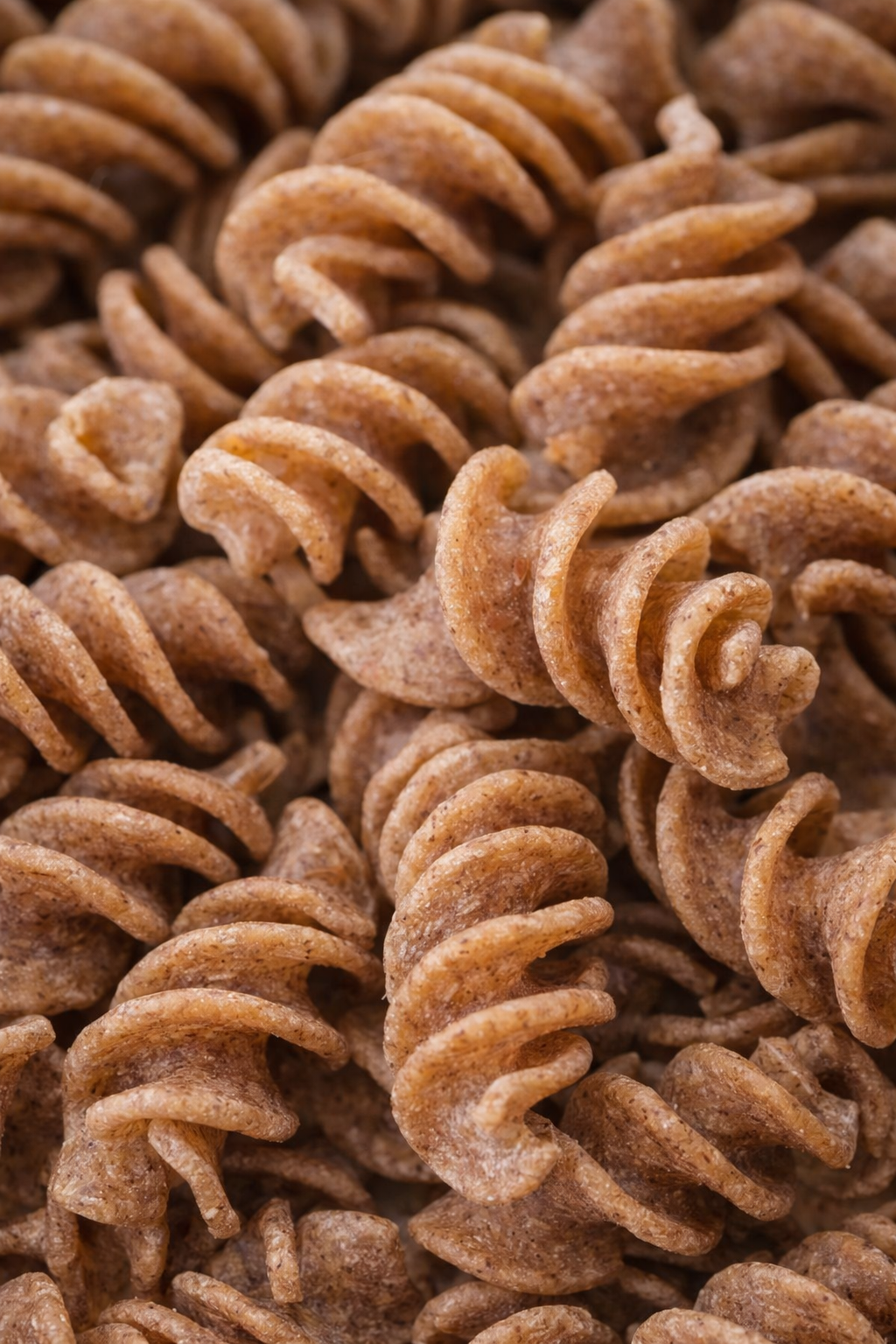 Close-up of uncooked whole wheat rotini pasta