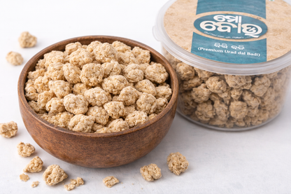 Bowl and container of urad dal with a brand label on a white background